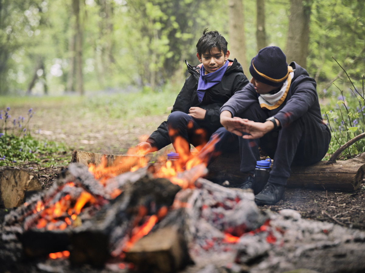 Image of 2 Scouts sat by a fire